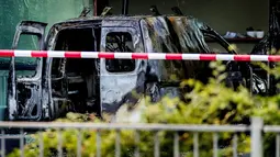 Sebuah mobil van hangus setelah menabrak pintu depan gedung tempat surat kabar ternama Belanda, De Telegraaf di Amsterdam, Selasa (26/6). Meski tak menimbulkan korban, namun aksi tabrakan itu menyebabkan kerusakan pada gedung. (KOEN VAN WEEL/ANP/AFP)