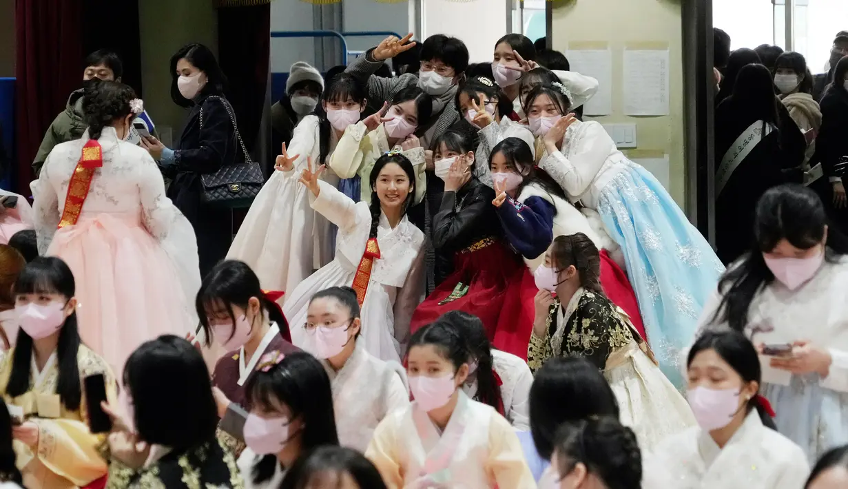 Siswa sekolah menengah atas yang mengenakan pakaian tradisional berpose untuk foto suvenir mereka saat upacara kelulusan dan kedewasaan bersama di Sekolah Menengah Wanita Dongmyung, Seoul, Korea Selatan, 7 Februari 2023. Sekolah menengah atas di Korea Selatan mengajar siswa selama tiga tahun, dari kelas satu (usia 15–16) hingga kelas tiga (usia 17–18), dan siswa biasanya lulus pada usia 17 atau 18 tahun. (AP Photo/Ahn Young-joon)