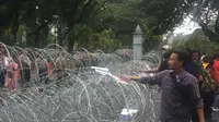 Sejumlah pedemo berusaha merusak barikade kawat berduri di sekitar Bundaran Patung Kuda, Silang Monas, Jakarta Pusat. (Radityo Proyasmoro/Liputan6.com)