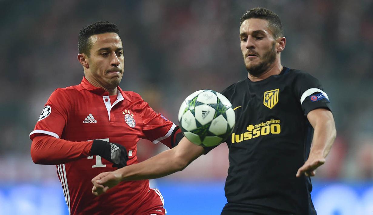 Gelandang Bayern Munchen, Thiago Alcantara, berusaha merebut bola dari gelandang Atletico Madrid, Koke. Munchen menguasai jalannya laga dengan penguasaan bola mencapai 68 persen. (AFP/Christof Stache)