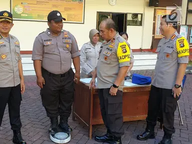 Kepala Biro SDM Polda Gorontalo Kombes Pol Murbani Budi Pitono (kedua kiri) mengecek pengukuran berat badan personel obesitas usai apel pagi di lapangan apel Mapolda Gorontalo, Senin (13/5/2019). Personel yang memiliki berat badan berlebih dikumpul dan ditimbang. (Liputan6.com/Arfandi Ibrahim)