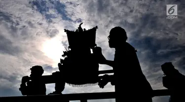 Umat Hindu mengarak Jempana berisikan sesaji dan benda sakral yang disucikan menuju Pura Segara, Cilincing, Jakarta, Minggu (3/3). Melasti merupakan upacara penyucian diri untuk menyambut Hari Raya Nyepi. (merdeka.com/Iqbal S Nugroho)