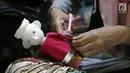 Perajin, menggunting baju miniatur ondel-ondel dari botol plastik di rumah produksi Kramat Jati, Jakarta, Rabu (28/11). Miniatur yang terbuat dari plastik diproduksi 50-80 buah dengan omset 5-8 Juta perbulan. (Liputan6.com/Herman Zakharia)