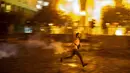 Seorang pengunjuk rasa antipemerintah melemparkan kembali tabung gas air mata ke arah polisi antihuru-hara selama protes terhadap elite politik yang telah memerintah negara selama beberapa dekade di Beirut, Lebanon, Jumat (7/8/2020). (AP Photo/Hassan Ammar )