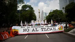 Petani Meksiko membentangkan spanduk saat melakukan demontrasi terkait NAFTA di Mexico City (26/7). Lebih dari seribu petani menggelar demo untuk memprotes impor biji-bijian dari AS yang lebih murah. (AP Photo / Rebecca Blackwell)