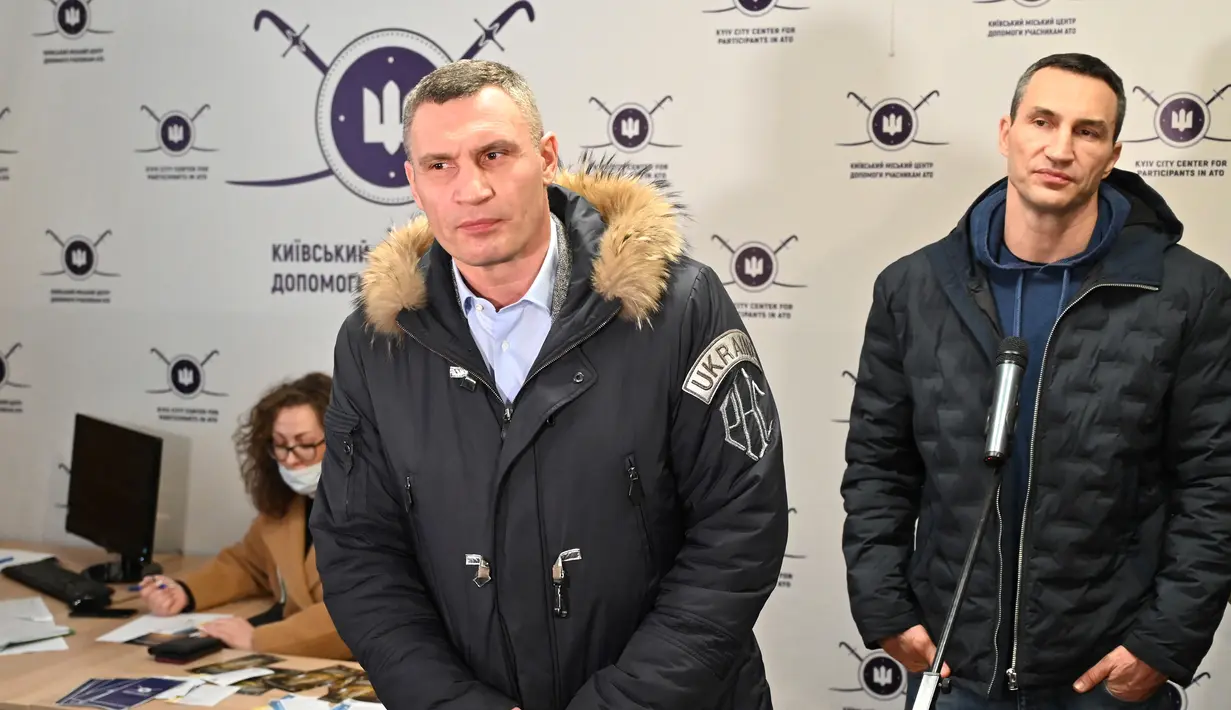 Wali Kota Kiev, Vitali Klitschko (kiri) dan saudaranya yang mantan petinju Ukraina Wladimir Klitschko berbicara kepada pers saat pembukaan pusat rekrutmen Pasukan Pertahanan Wilayah di Kiev, 2 Februari 2022. Wladimir Klitschko mendaftar menjadi tentara cadangan Ukraina. (Genya SAVILOV/AFP)