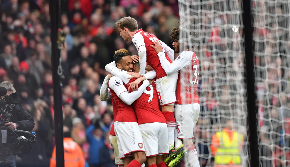 Pemain Arsenal merayakan gol yang diciptakan Pierre-Emerick Aubameyang saat melawan Stoke City dalam pertandingan Liga Inggris di Stadion Emirates, London (4/1). Arsenal 3-0 menang atas Stoke City. (AFP Photo/Oliver Greenwood)