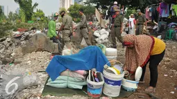 Warga mengumpulkan barang miliknya di kawasan TPU Menteng Pulo, Jakarta Selatan (7/4). Lebih dari seratus kepala keluarga digusur karena mereka menempati lahan dan mendirikan bangunan di tempat pemakaman umum. (Liputan6.com/Gempur M Surya)