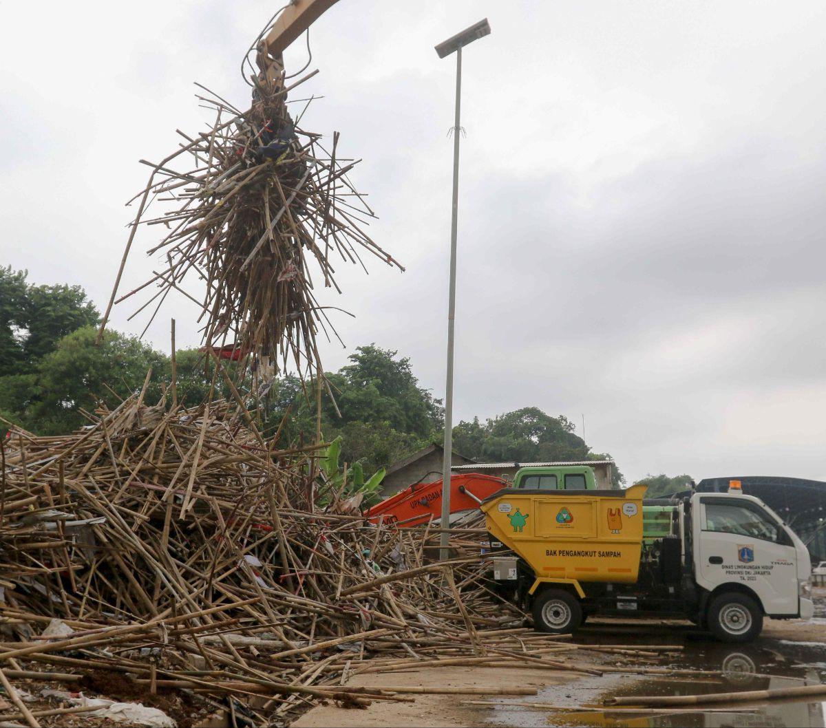 Tumpukan bambu yang merupakan limbah alat peraga kampanye dipindahkan menggunakan alat berat di&nbsp;tempat penyaringan sampah di TB Simatupang, Jakarta, Jumat (16/2/2024).&nbsp;Dinas Lingkungan Hidup (DLH) DKI Jakarta mengumpulkan&nbsp;sampah alat peraga