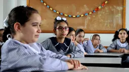 Para siswa duduk dalam kelas pada hari pertama tahun ajaran baru di kamp pengungsi Shati, Gaza City, Palestina, 8 Agustus 2020. Siswa Palestina dari Jalur Gaza memulai tahun ajaran baru setelah sekolah ditutup selama lima bulan karena COVID-19. (Xinhua/Rizek Abdeljawad)