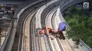 Pekerja menyelesaikan pembangunan LRT (Light Right Transit) Jabodebek di kawasan Kampung Makasar, Jakarta, Sabtu (26/10/2019). LRT akan diuji coba pada awal November 2019. (Liputan6.com/JohanTallo)