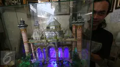Seorang perajin, Albani, menunjukkan mahar pernikahan berbentuk miniatur masjid, di dusun Jotowang, Yogyakarta, Rabu (15/6). Pada Ramadan, pemesanan miniatur masjid berbahan dasar uang pecahan rupiah itu mengalami peningkatan. (Liputan6.com/Boy Harjanto)