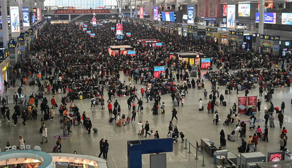 Penumpang menunggu jadwal keberangkatan mereka di Stasiun Kereta Hongqiao di Shanghai pada Senin (20/1/2020). China berada di tengah-tengah kesibukan migrasi manusia tahunan ketika jutaan orang pulang ke kampung halaman mereka untuk menikmati libur Tahun Baru Imlek. (HECTOR RETAMAL/AFP)