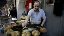 Pedagang membuat kudapan Falafel untuk menu berbuka puasa selama Ramadan di Kota Nablus, Tepi Barat, Minggu (26/4/2020). (AP Photo/Majdi Mohammed)