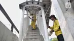 Petugas dari dinas terkait melakukan pengecatan di Jembatan Penyeberangan Orang (JPO) yang sudah diperbaiki di kawasan Daan Mogot, Jakarta Barat, Rabu (16/4/2025). (Liputan6.com/Angga Yuniar)