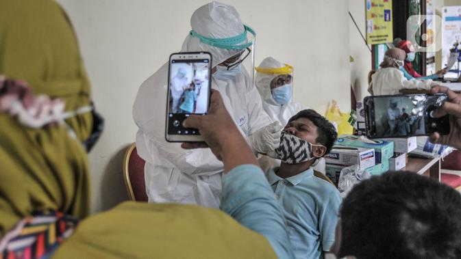 Orang tua mendampingi anaknya saat menjalani tes Covid-19 di GOR Kecamatan Makasar, Jakarta, Senin (17/5/2021) (merdeka.com/Iqbal S Nugroho)