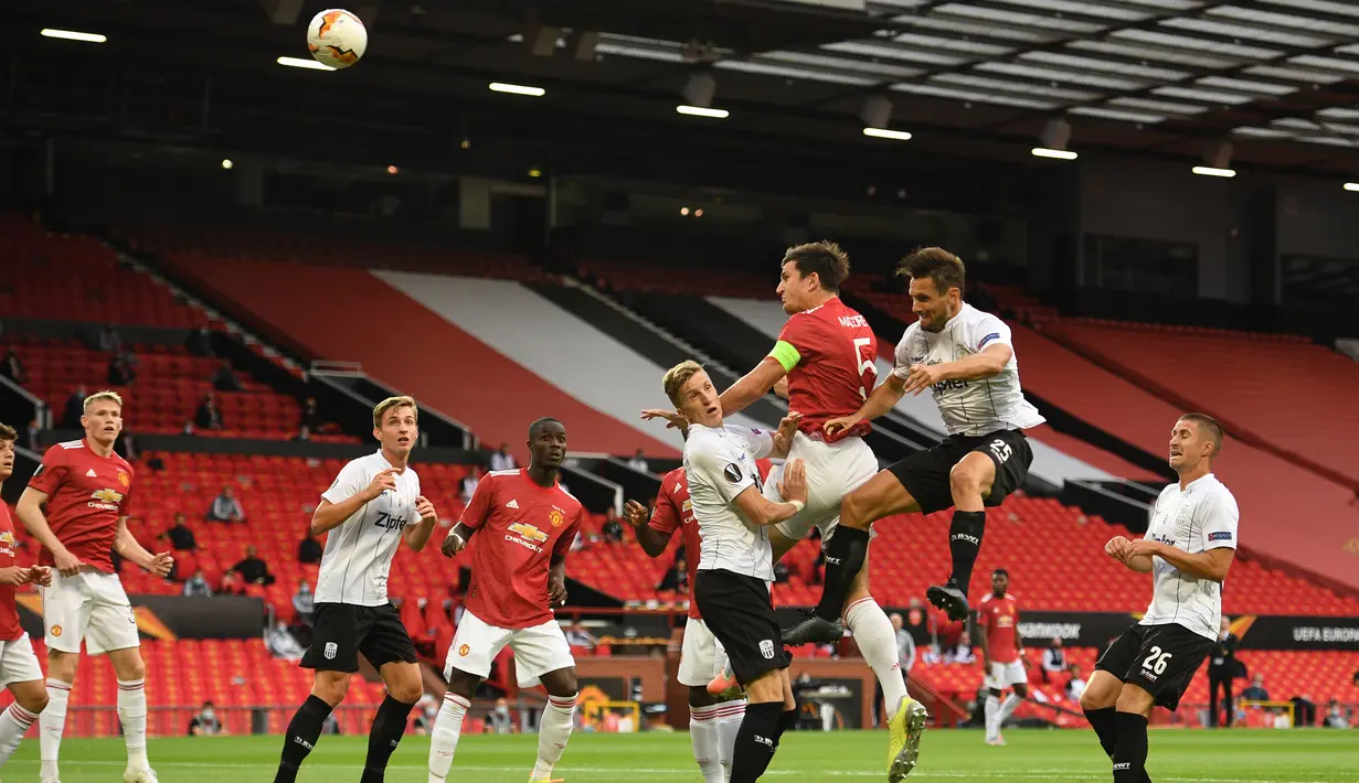 Bek Manchester United, Harry Maguire, berebut bola dengan pemain LASK pada laga leg kedua 16 besar Liga Europa 2019/2020 di Old Trafford, Kamis (6/8/2020) dini hari WIB. Manchester United menang agregat 7-1 atas LASK. (AFP/Oli Scarff)