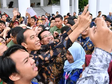 Presiden Joko Widodo berselfie dengan Peserta Kongres Indonesia Millenial Movement Tahun 2018 di Istana Bogor, Jawa Barat, Senin (12/11). (Liputan6.com/Pool/Laily Rachev-Biro Pers Setpres)