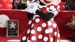 Kartun Disney, Minnie Mouse berpose dekat bintang Hollywood Walk of Fame miliknya saat acara penghargaan di Los Angeles, Senin (22/1). Bintang yang mengukir nama Minnie adalah yang ke-2.627 di Hollywood Walk of Fame. (Richard Shotwell/Invision/AP)