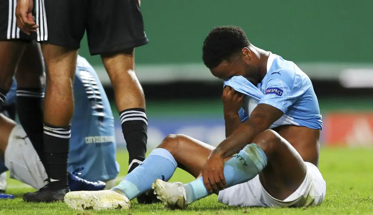 Pemain Manchester City, Raheem Sterling, menutup wajahnya usai ditaklukkan Lyon pada perempat final Liga Champions di Stadion Jose Alvalade, Sabtu (15/8/2020). Lyon menang 3-1 atas Manchester City. (Miguel A. Lopes/Pool via AP)