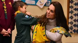 Seorang anak melilitkan kain Kate Middleton saat rekayasa pemberian pertolongon pertama dalam  acara Cub Scout Pack di Kings Lynn, Inggris (14/12). Kate memang dikenal sering berpartisipasi dalam acara Pramuka setiap tahunnya. (Reuters/Ben Stansall/Pool)