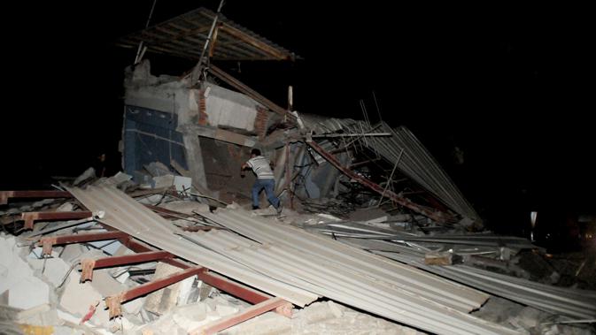 Seorang warga mencari korban di reruntuhan bangunan pasca diguncang Gempa berkekuatan 7,8 SR, Kota Manta, Ekuador, Sabtu (16/4).Kabarnya gempa yang terjadi di lepas pantai Pasifik itu berpotensi menimbulkan tsunami. (REUTERS/Paul Ochoa)