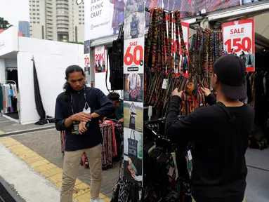 Warga melihat barang di salah satu stand yang memajang pakaian produksi dalam negeri saat pembukaan Jakarta Clothing Expo (JakCloth) 2023 di Parkir Timur Senayan, Jakarta, Rabu (5/7/2023). (Liputan6.com/Johan Tallo)