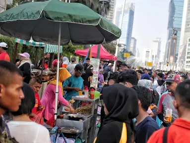 Pedagang kaki lima (PKL) berjualan saat pelaksanaan CFD di kawasan Bundaran HI, Jakarta, Minggu (5/5/2019). Kurangnya pengawasan petugas menyebabkan banyak PKL berjualan tidak pada tempat yang telah di sediakan Pemprov DKI sehingga mengganggu aktivitas warga berolahraga. (Liputan6.com/Faizal Fanani)