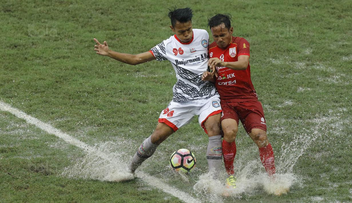 Gelandang Martapura FC, Reza Saputra, berebut bola dengan gelandang Persis Solo, Eli Nasoka, pada laga 8 besar Liga 2 Indonesia di Stadion Patriot, Bekasi, Kamis (9/11/2017). Persis kalah 0-1 dari Martapura FC. (Bola.com/M Iqbal Ichsan)