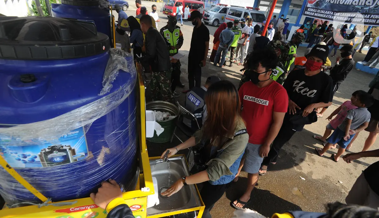 Sejumlah orang antre mencuci tangan saat petugas melakukan sterilisasi kendaraan yang ingin menuju wilayah Sukabumi di Terminal Cicurug, Sukabumi, Jawa Barat, Minggu (12/4/2020). Proses sterilisasi ini dilakukan untuk mencegah penyebaran virus corona COVID-19. (merdeka.com/Arie Basuki)