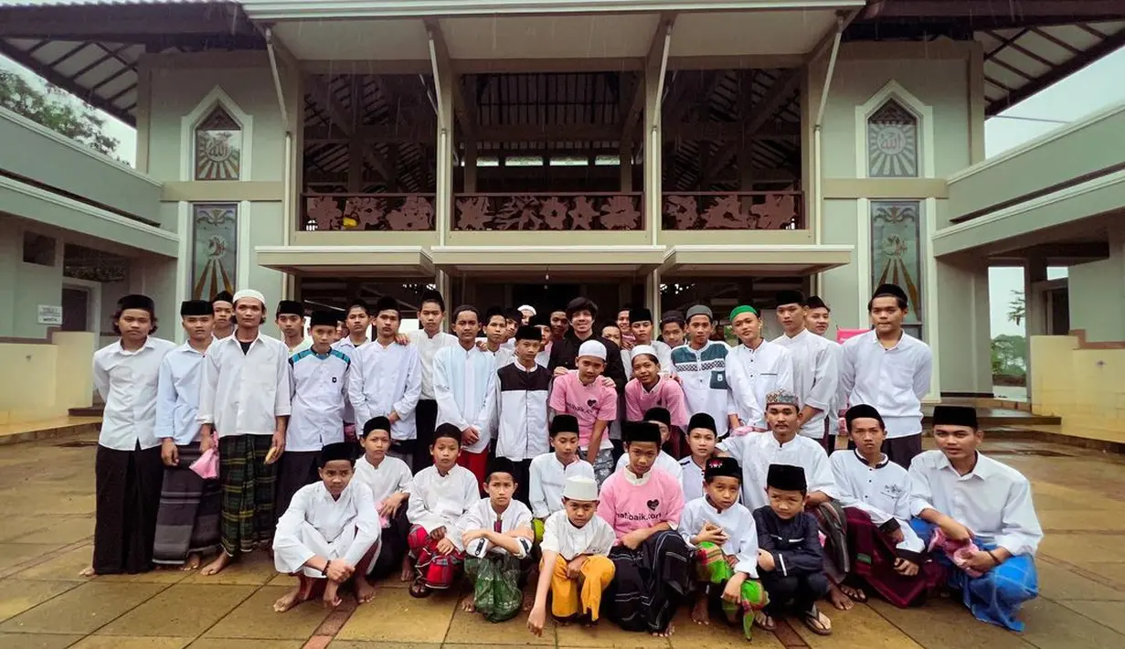 Bapak satu anak ini mengajak para santri untuk foto bersama di depan halaman pondok pesantren. (Foto: Instagram/@attahalilintar)