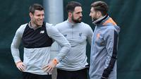 Pemain Liverpool, James Milner, Danny Ings dan Adam Lallana berbincang saat latihan di Melwood Training Ground, Liverpool, (5/3). Liverpool akan melawan Porto pada leg kedua babak 16 besar Liga Champions. (AFP Photo/Anthony Devlin)