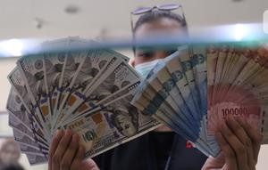 Petugas menunjukkan uang rupiah di penukaran uang, Jakarta, Senin (9/11/2020). ). Nilai tukar rupiah terhadap dolar AS bergerak menguat pada perdagangan di awal pekan ini Salah satu sentimen pendorong penguatan rupiah kali ini adalah kemenangan Joe Biden atas Donald Trump. (Liputan6.com/Angga Yuniar