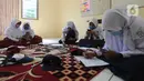 Murid-murid SD dan SMP belajar dengan memanfaatkan wifi gratis di Balai RW kawasan Tegal Gundil, Bogor, Jawa Barat, Senin (21/9/2020). Pemkot Bogor menyebar lebih dari 50 titik wifi publik gratis untuk menunjang Pembelajaran Jarak Jauh (PJJ) siswa di Kota Bogor. (merdeka.com/Arie Basuki)