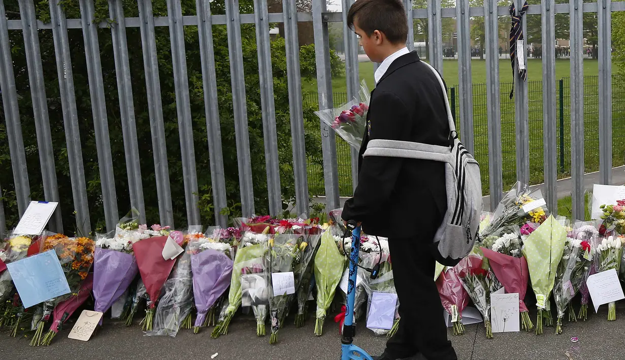 Seorang siswa memberikan bunga sebagai tanda duka atas kematian mengenaskan guru mereka, Anne Maguire, Leeds, Inggris utara, Selasa (29/04/2014) (Reuters/Darren Staples).