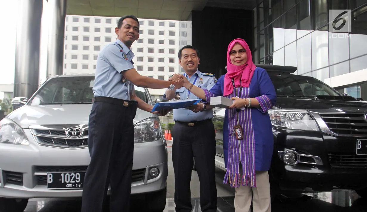Plt Koordinator Unit Kerja Labuksi KPK Irene Putri menyerahkan barang sitaan ke Direktur Pelayanan Tahanan dan Pengelolaan Benda Sitaan dan Barang Rampasan Negara Wahidin di Gedung KPK Jakarta, Selasa (30/1). (Liputan6.com/Herman Zakharia)