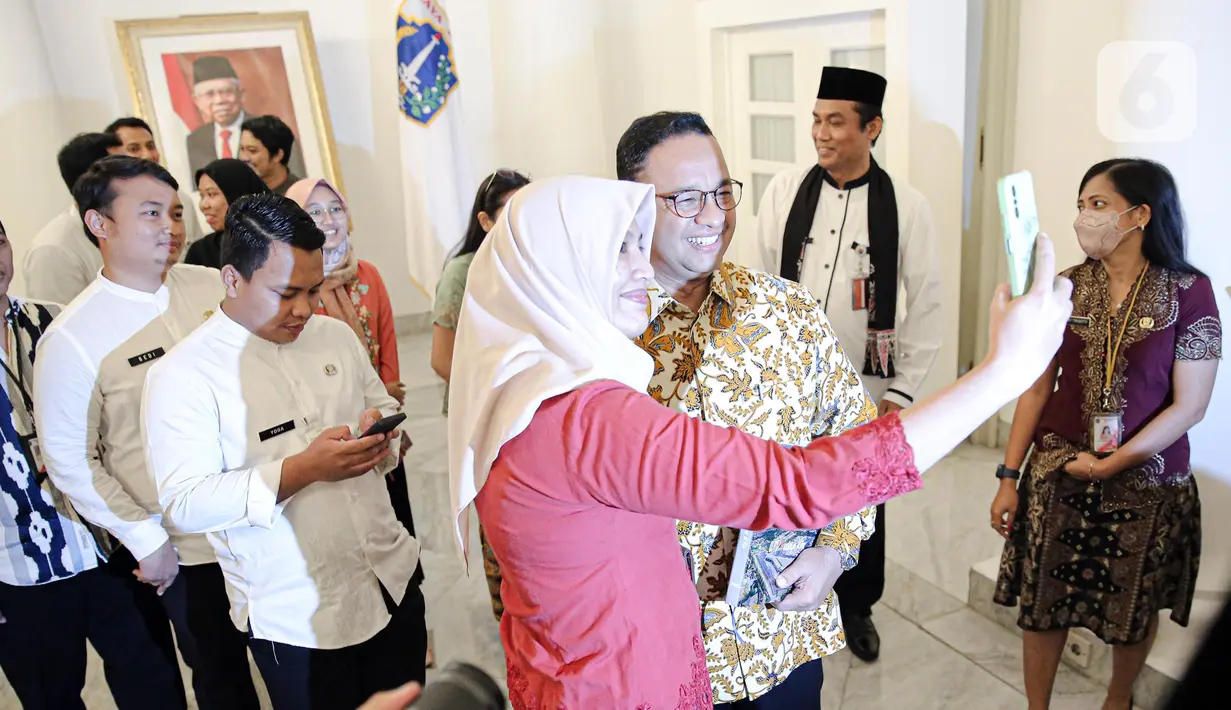Gubernur DKI Jakarta Anies Baswedan foto bersama Aparatur Sipil Negara (ASN) di Balai Kota DKI Jakarta, Jumat (14/10/2022). Di hari terakhir menjabat sebagai Gubernur DKI Jakarta, Anies Baswedan menyempatkan diri untuk menyapa ASN di Balai Kota. (Liputan6.com/Faizal Fanani)