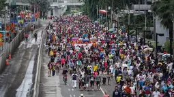 Ribuan orang memadati jalan MH Thamrin Jakarta saat Hari Bebas Kendaraan Bermotor (HBKB) terakhir di tahun 2014, Jakarta, Minggu (28/12/2014). (Liputan6.com/Faizal Fanani)