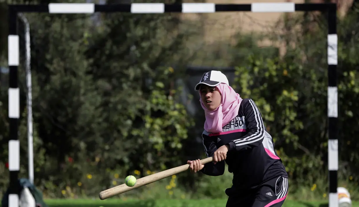 Seorang wanita Palestina memukul bola saat mengikuti sesi latihan bisbol di Khan Younis, Jalur Gaza, 19 Maret 2017. Sekelompok wanita muda muslim mencoba olahraga bisbol sebagai hiburan. (AP Photo/Khalil Hamra)