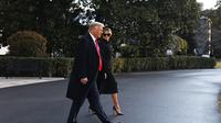 Donald Trump dan Melania Trump meninggalkan Gedung Putih di Washington, DC, pada 20 Januari 2021. Presiden Trump melakukan perjalanan ke kediaman klub golf Mar-a-Lago di Palm Beach, Florida. (MANDEL NGAN / AFP)