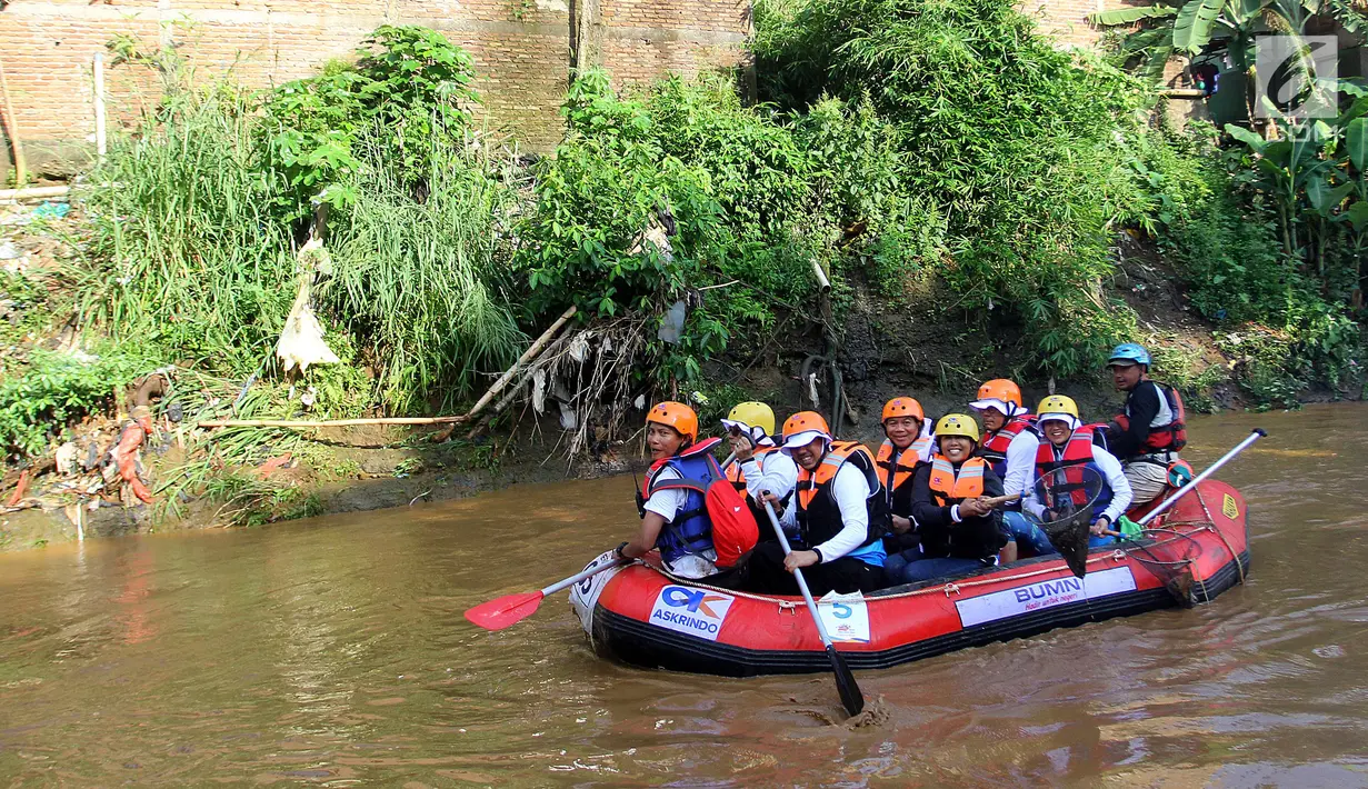 Aksi Menteri BUMN Rini M Soemarno saat membersihkan sampah Sungai Ciliwung dengan naik perahu karet pada acara Bersih-Bersih Sungai Ciliwung, Jakarta, Minggu (08/4).(Liputan6.com/Fery Pradolo)