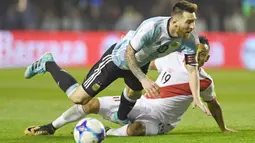 Kapten Argentina, Lionel Messi (kiri) terjatuh saat berebut bola dengan  pemain Peru, Victor Yotun pada laga Kualifikasi Piala Dunia 2018 di Buenos Aires, (5/10/2017). Argentina bermain imbang 0-0 lawan Peru. (AFP/Eitan Abramovich)