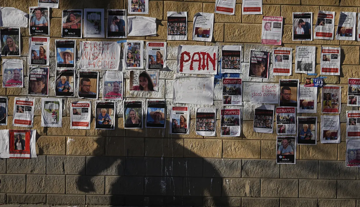 Puluhan poster kecil, masing-masing menggambarkan seorang warga Israel yang hilang, sementara sebuah tanda lain hanya bertuliskan satu kata, ditulis dengan warna merah terang: "Rasa sakit." (AP Photo/Ohad Zwigenberg)
