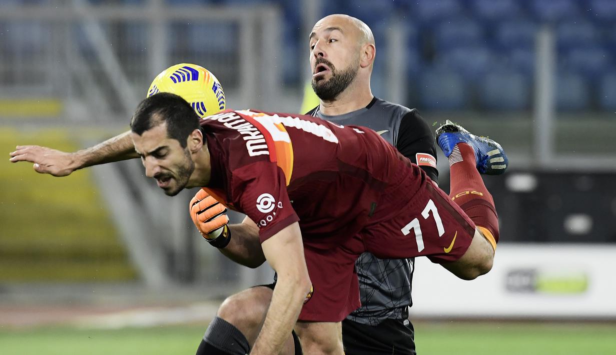 Gelandang AS Roma, Henrikh Mkhitaryan (depan) berebut bola dengan kiper Lazio, Pepe Reina dalam laga lanjutan Liga Italia Serie A 2020/21 pekan ke-18 di Olympic Stadium, Roma, Jumat (15/1/2021). AS Roma kalah 0-3 dari Lazio. (AFP/Filippo Monteforte)