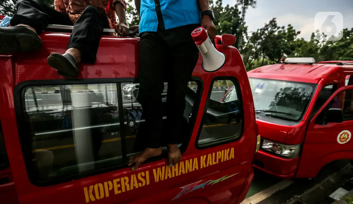Sopir angkot Koperasi Wahana Kalpika (KWK) membawa pengeras suara untuk berorasi saat menggelar aksi di Balai Kota DKI Jakarta, Rabu (2/8/2023). (Liputan6.com/Faizal Fanani)