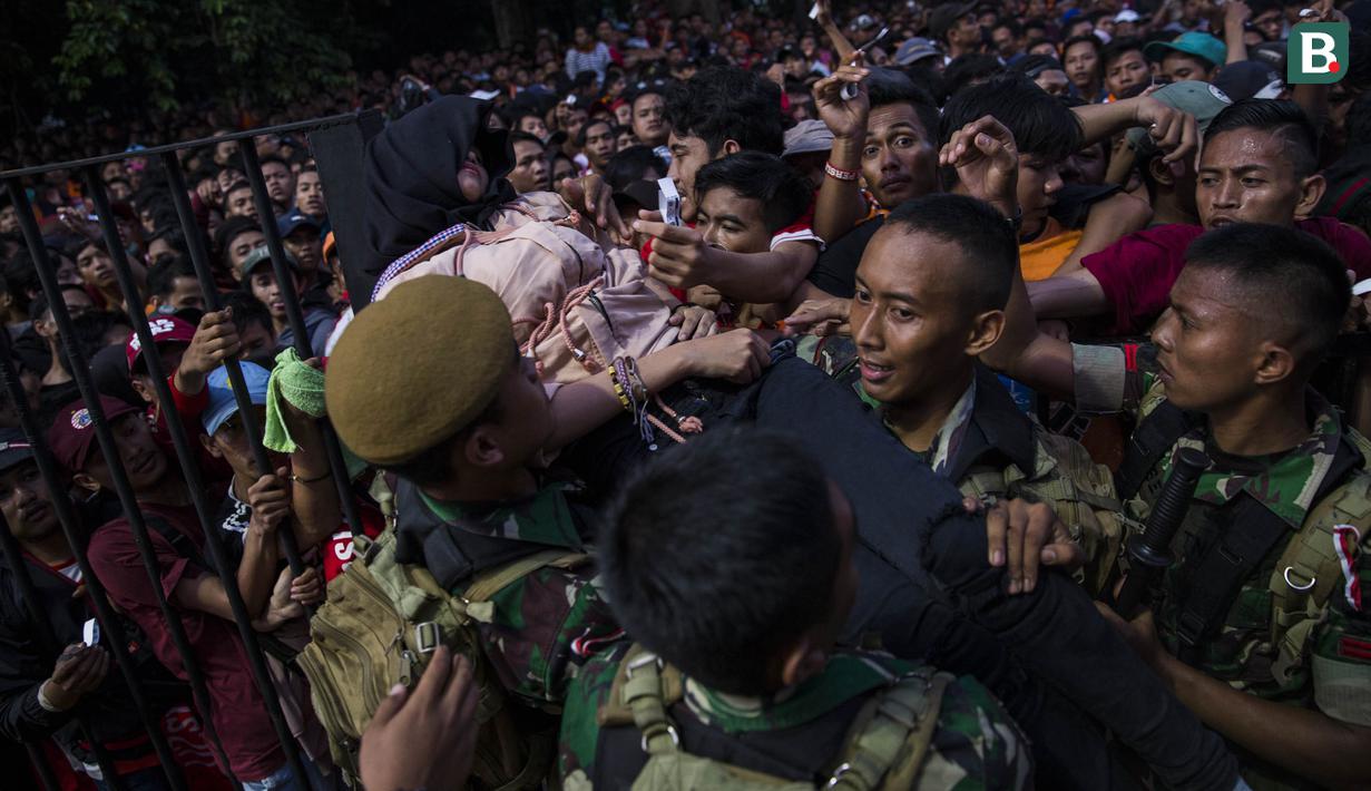 Petugas mengamankan suporter Persija Jakarta, The Jakmania, yang pingsan jelang final Piala Presiden di sekitar SUGBK, Jakarta, Sabtu (17/2/2018). Persija akan menghadapi Bali United. (Bola.com/Vitalis Yogi Trisna)