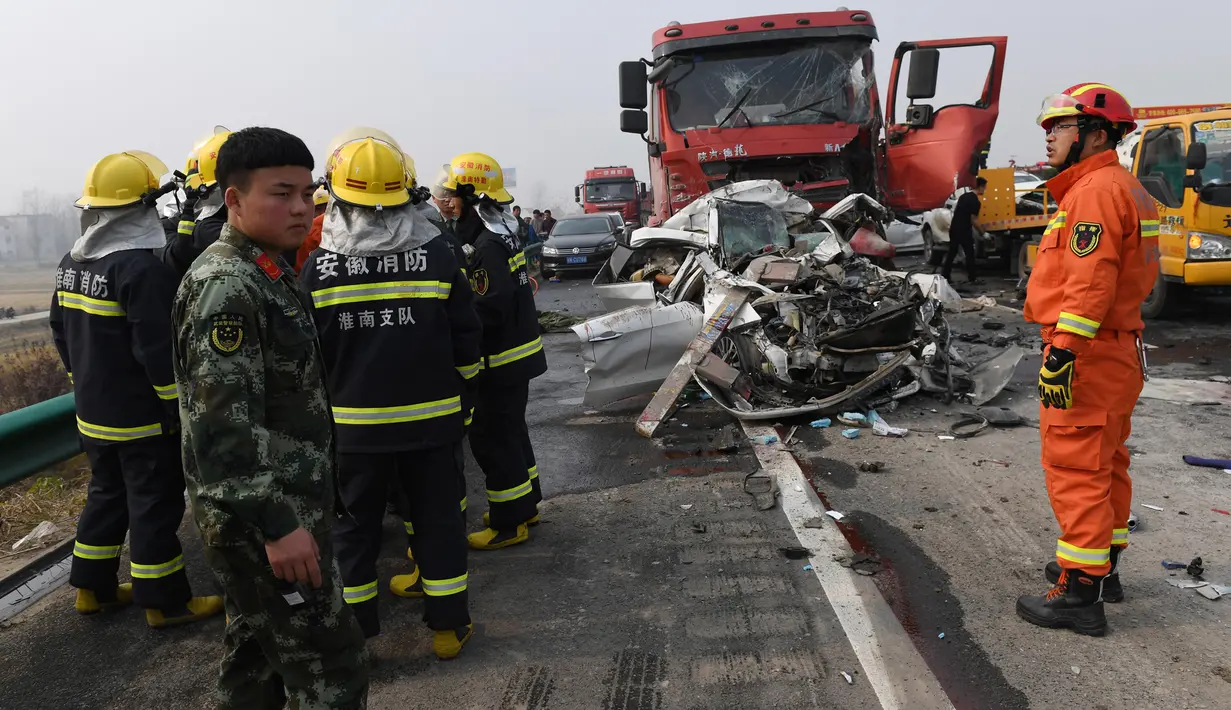 Petugas pemadam kebakaran dikerahkan ke lokasi kecelakaan beruntun 30 kendaraan di jalan raya dekat Yingshang, China timur, Rabu (15/11). Tak hanya mobil penumpang ukuran sedang saja yang terbakar hangus melainkan juga beberapa unit truk. (STR / AFP)