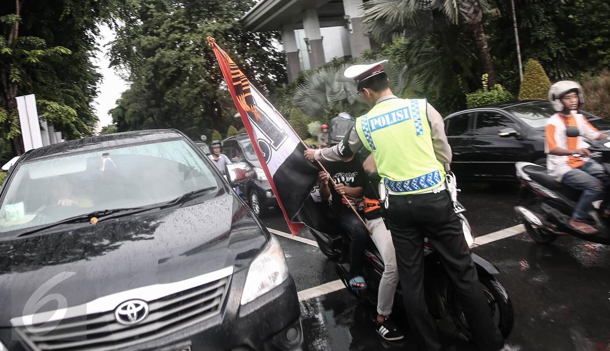 Petugas kepolisian merazia  suporter yang membawa bendera dengan  tongkat disekitar kawasan Gelora Bung Karno, Jakarta, Minggu (8/5/2016). Razia tersebut dilakukan untuk mengatisipasi keributan antar supporter. (Liputan6.com/Faizal Fanani)