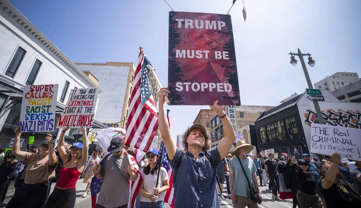Demonstrasi ini terjadi menyusul gelombang protes atas razia terhadap para migran yang dimulai sekitar dua minggu lalu, yang diikuti perintah Trump untuk mengirim Garda Nasional dan marinir ke Los Angeles. (RINGO CHIU/AFP)