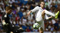 Aksi pemain Real Madrid, Gareth Bale (kanan)  mengadang sepakan kiper Levante, Raul Fernandez pada lanjutan La Liga di Santiago Bernabeu stadium, Madrid (9/9/2017). Madrid bermain imbang 1-1. (AFP/Pierre-Philippe Marcou)